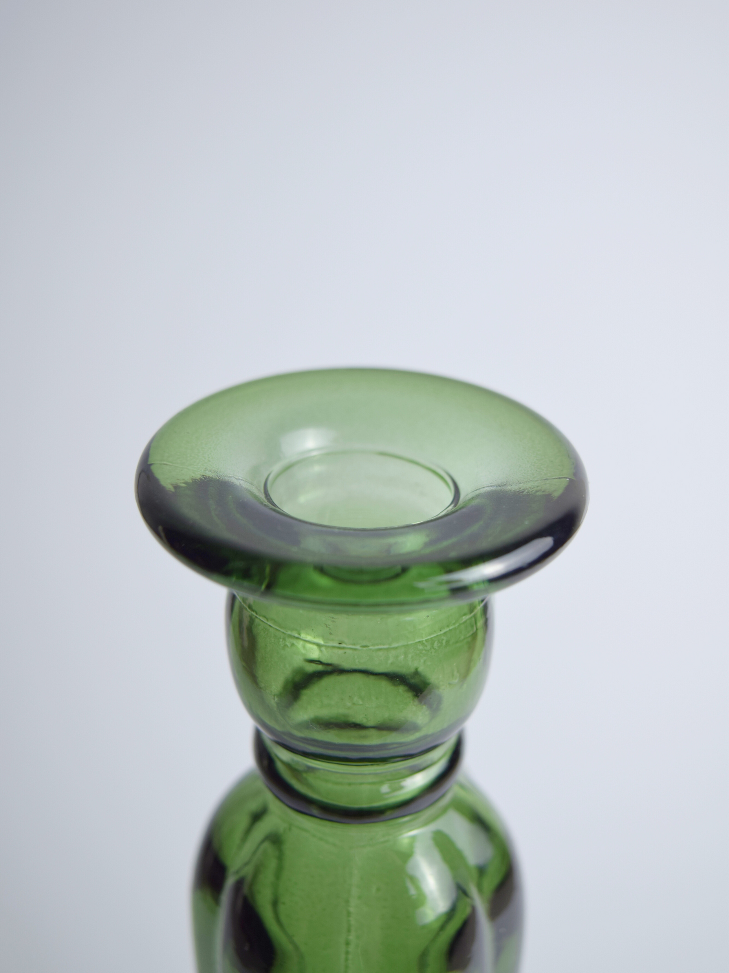 Nahaufnahme eines grünen Kerzenhalters aus Recyclingglas auf hellem Hintergrund