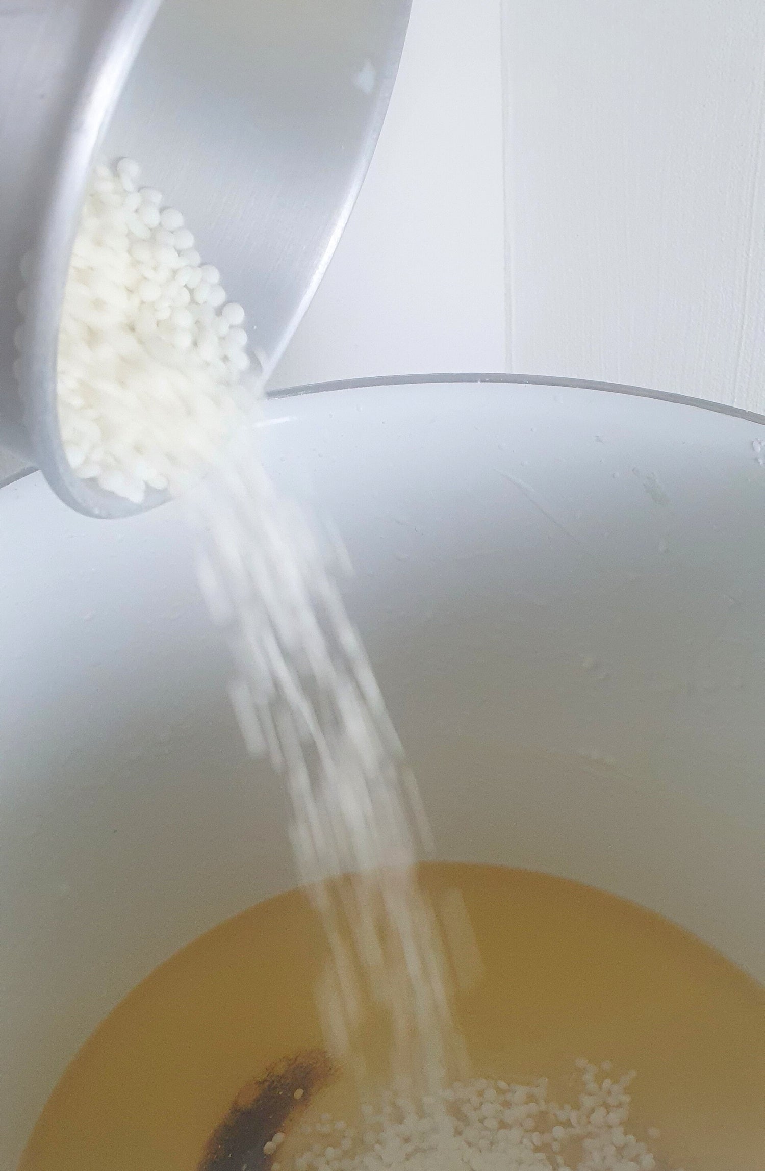 Giessen von Wachspastillen in einen Wachsschmelzer