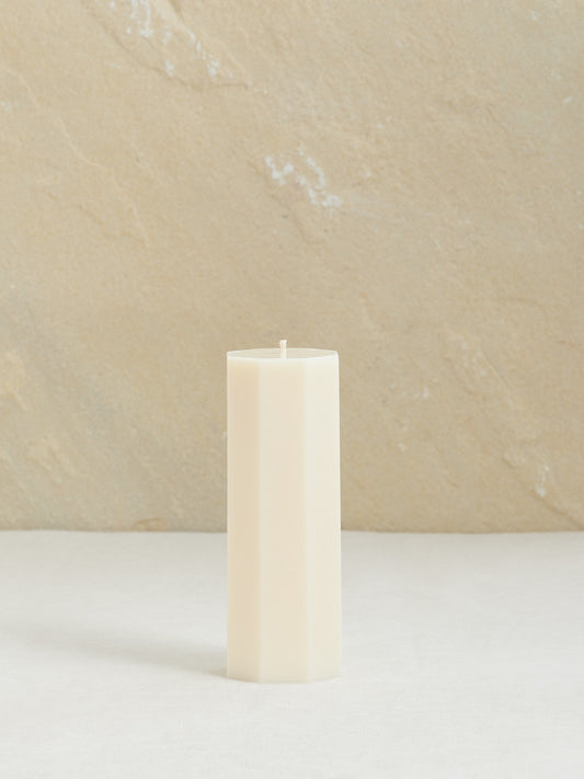 Minimalistische, achteckige Dekokerze auf neutralem Hintergrund, naturweiss